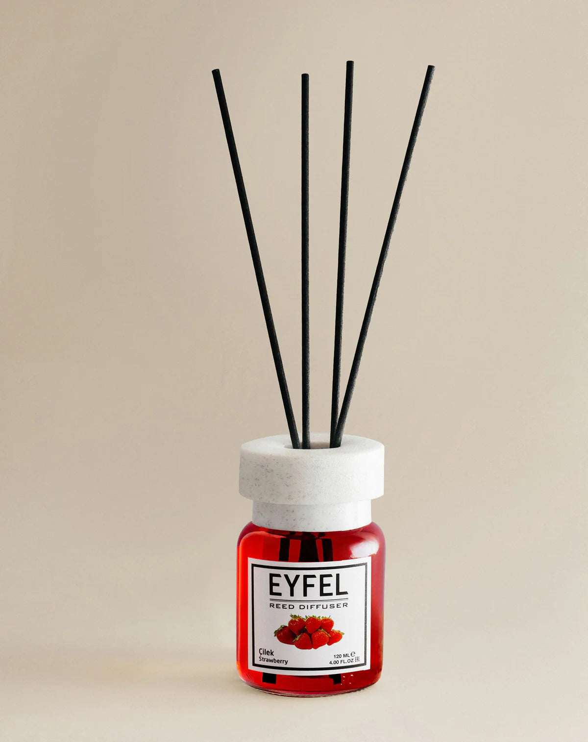 Reed diffuser with black sticks and red container labeled 'Eyfel' on a beige background