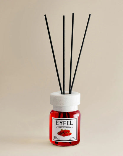 Reed diffuser with black sticks and red container labeled 'Eyfel' on a beige background